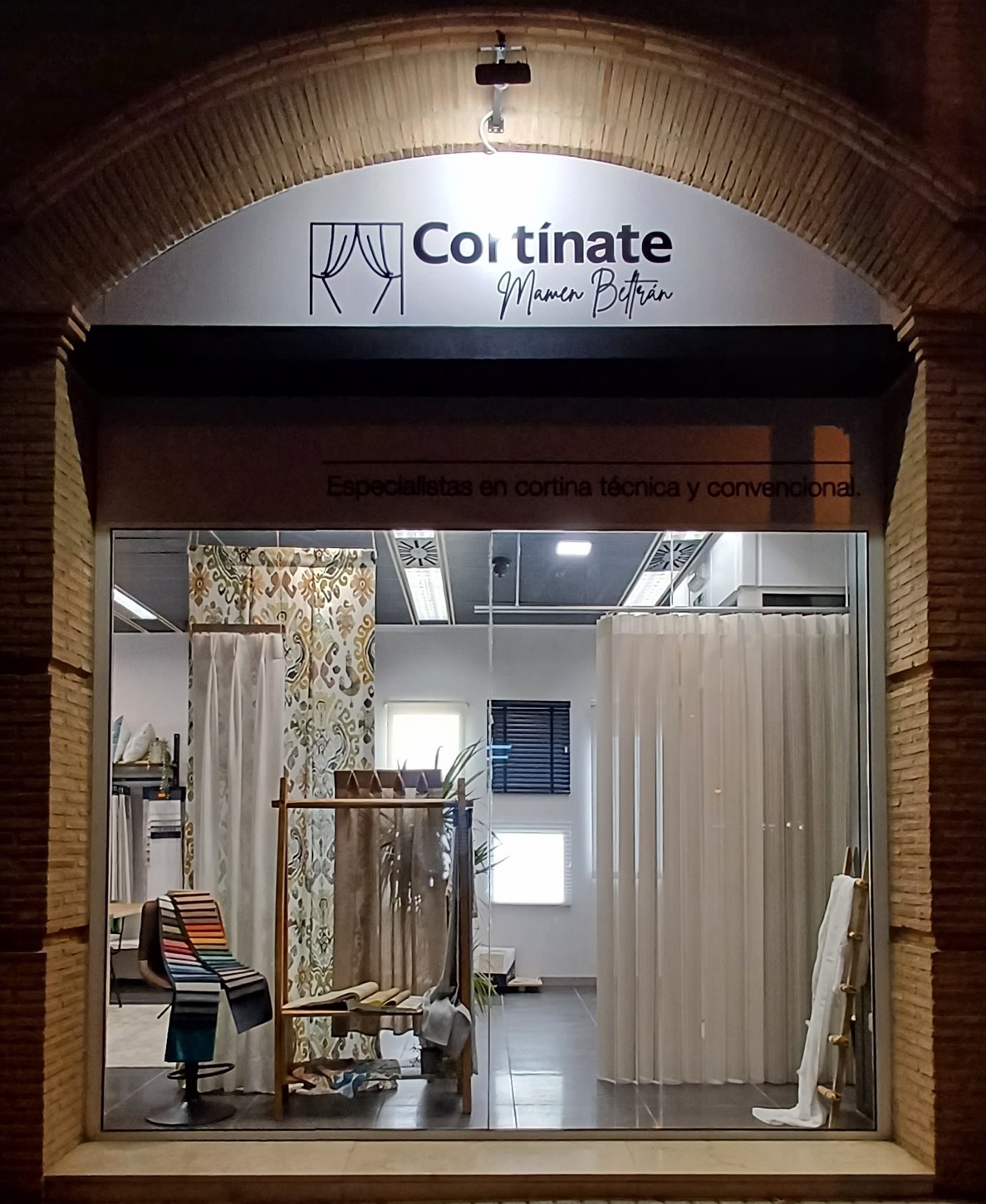 Fachada del estudio Cortínate Mamen Beltrán en Alboraya, de noche, con el escaparate iluminado