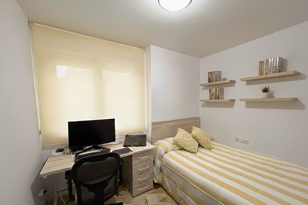 Dormitorio con escritorio y estor enrollable color crema